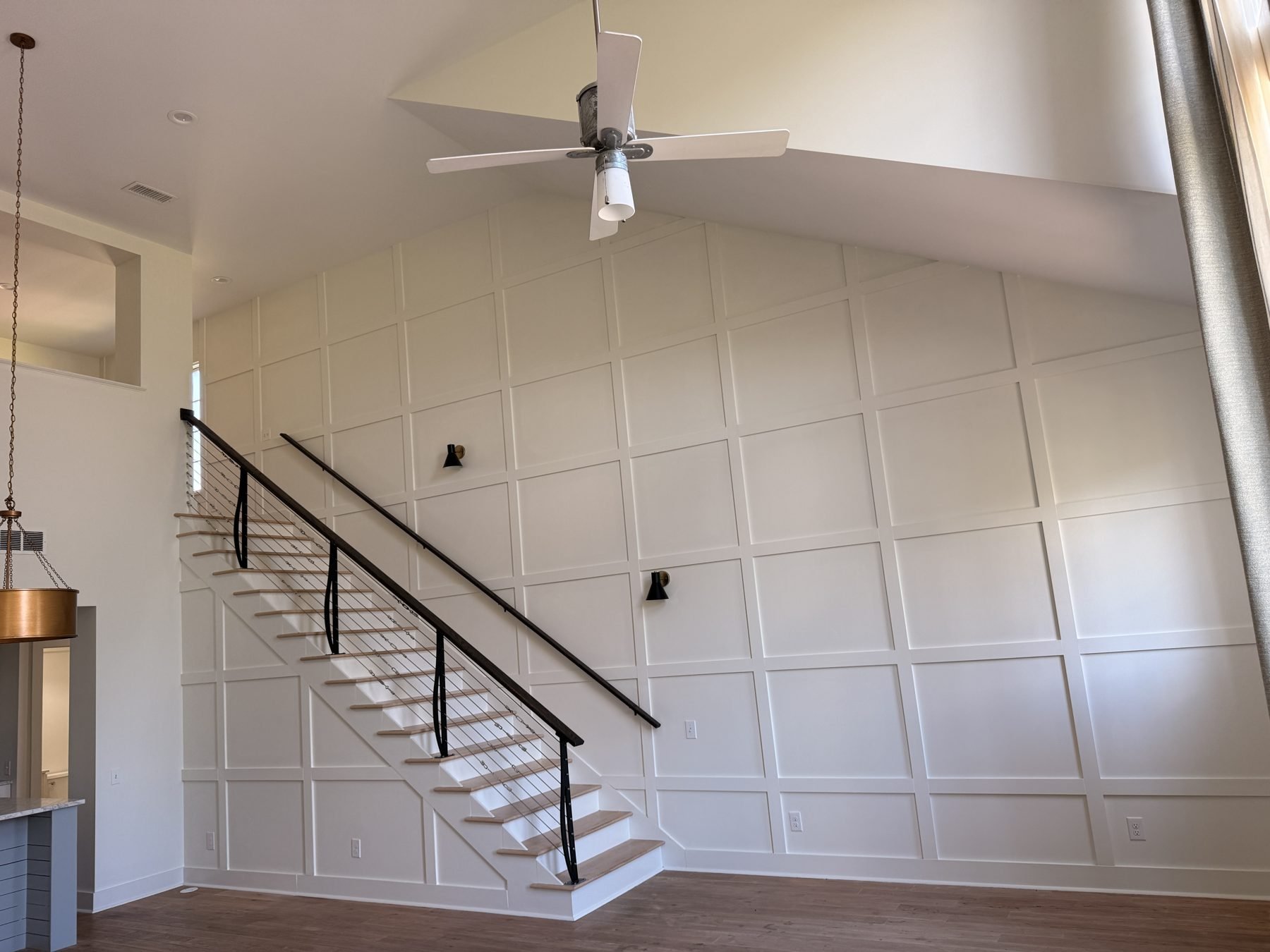 Paneled stair wall and cable rail staircase after renovation, The Hampstead Townhome, Hampstead, Montgomery
